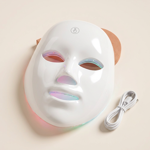 LED light face mask on a cream background
